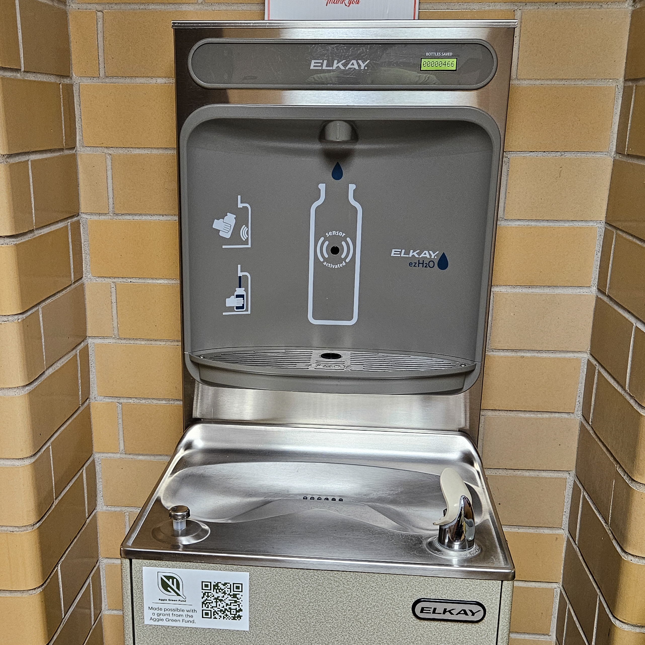 Retro water fountain with a water bottle filling station installed behind it and the Aggie Green Fund logo visible. 